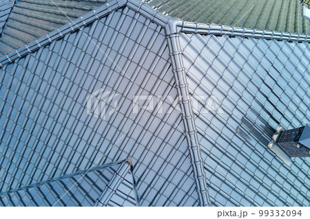 Closeup of house roof top covered with shiny ceramic shingles. 99332094