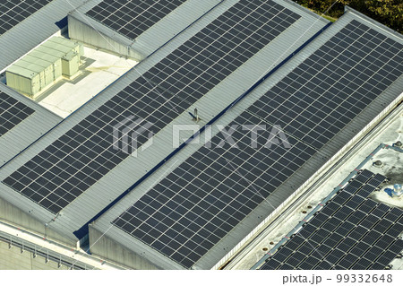 Aerial view of solar power plant with blue photovoltaic panels mounted on industrial building roof for producing green ecological electricity. Production of sustainable energy concept 99332648