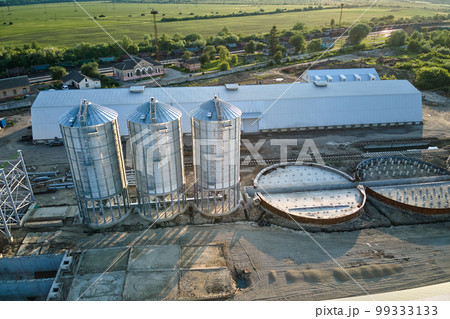 Aerial view of industrial ventilated silos for long term storage of grain and oilseed. Metal elevator for wheat drying in agricultural zone 99333133