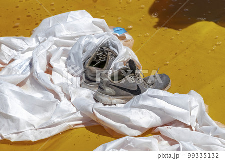 Photograph of running shoes in a chemical wash bath Photograph of running shoes in a chemical wash bath 99335132