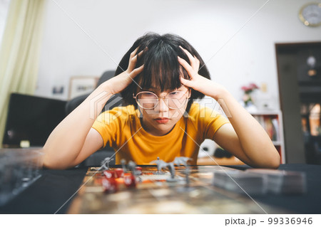 Young adult southeast asian woman playing board game on top table Young adult southeast asian woman playing board game on top table 99336946