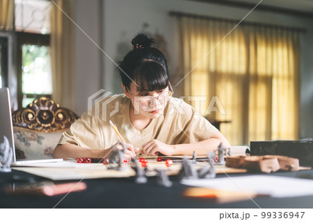 Young adult asian woman enjoying role playing tabletop and board game Young adult asian woman enjoying role playing tabletop and board game 99336947