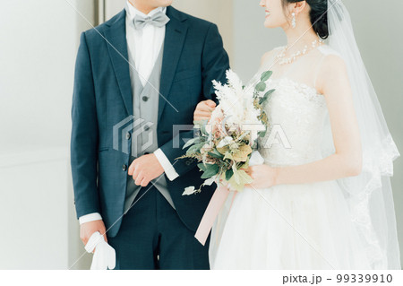 結婚式でチャペル・結婚式場・バージンロードにブーケを持って入場する新郎新婦 99339910