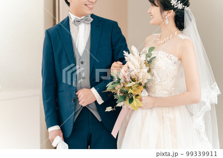 結婚式でチャペル・結婚式場・バージンロードにブーケを持って入場する新郎新婦 99339911