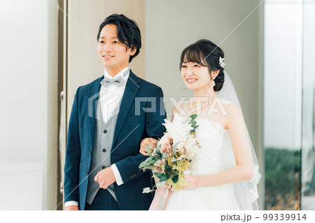 結婚式でチャペル・結婚式場・バージンロードにブーケを持って入場する新郎新婦 結婚式でチャペル・結婚式場・バージンロードにブーケを持って入場する新郎新婦 99339914