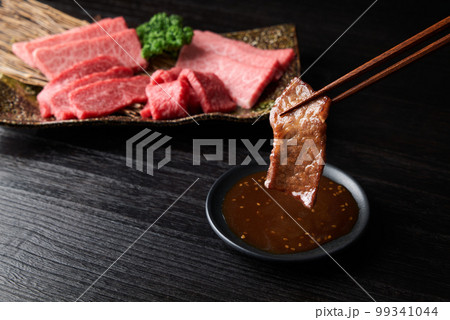 焼肉をタレに浸す 99341044