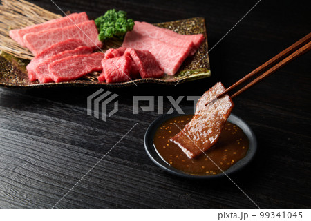 焼肉をタレに浸す 99341045