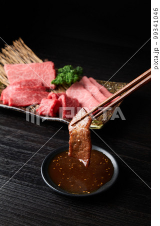 焼肉をタレに浸す 99341046