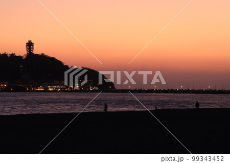 夕日が沈む鎌倉腰越海岸から見た江ノ島の風景 夕日が沈む鎌倉腰越海岸から見た江ノ島の風景 99343452