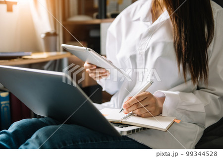 Woman using smart phone for mobile payments online shopping,omni channel,sitting on table,virtual icons graphics interface screen in morning light. 99344528