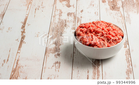 Plate with fresh ground beef on a brown wooden background, space for text, stock photo Plate with fresh ground beef on a brown wooden background, space for text, stock photo 99344996