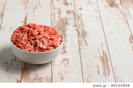 Plate with fresh ground beef on a brown wooden background, space for text, stock photo Plate with fresh ground beef on a brown wooden background, space for text, stock photo 99344998