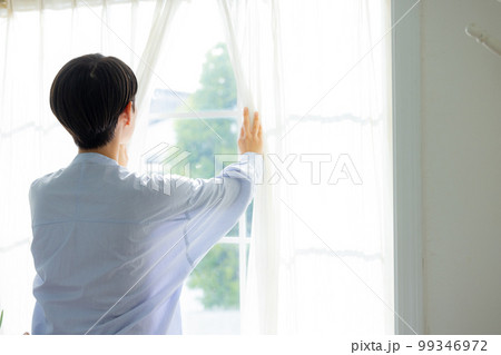 窓を開ける女性 99346972