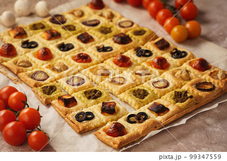 Puff pastry mini pies with cherry tomatoes, mushrooms, olives , feta cheese and onion. Puff pastry mini pies with cherry tomatoes, mushrooms, olives , feta cheese and onion. 99347559