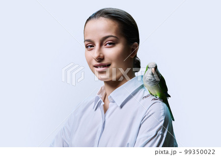 Young teenage female with green pet parrot, on white background 99350022