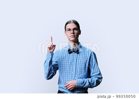 Serious guy student showing thumbs up, over white background Serious guy student showing thumbs up, over white background 99350050