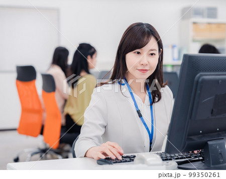笑顔でデスクワークをする女性 笑顔でデスクワークをする女性 99350261
