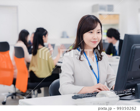笑顔でデスクワークをする女性 笑顔でデスクワークをする女性 99350262