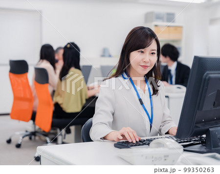 笑顔でデスクワークをする女性 笑顔でデスクワークをする女性 99350263