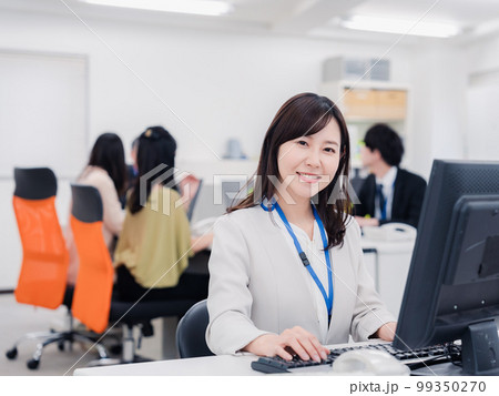 笑顔でデスクワークをする女性 99350270