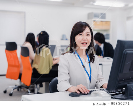 笑顔でデスクワークをする女性 笑顔でデスクワークをする女性 99350271