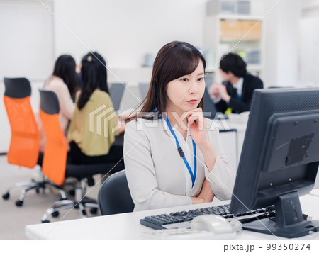 笑顔でデスクワークをする女性 99350274
