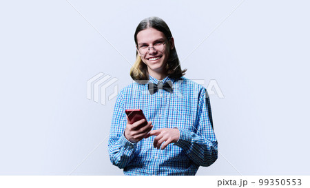 Young smart male with smartphone looking at camera on white background 99350553