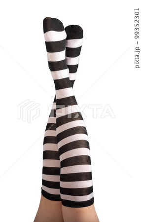 Women legs, feet raised up in striped black and white stockings, long socks isolated on white background Women legs, feet raised up in striped black and white stockings, long socks isolated on white background 99352301