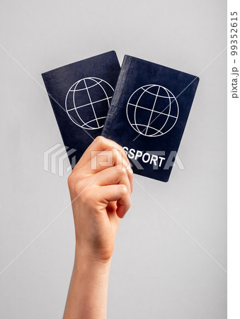 Woman hand with two passports. Family vacation, travel together concept. Identity, nationality verification. 99352615