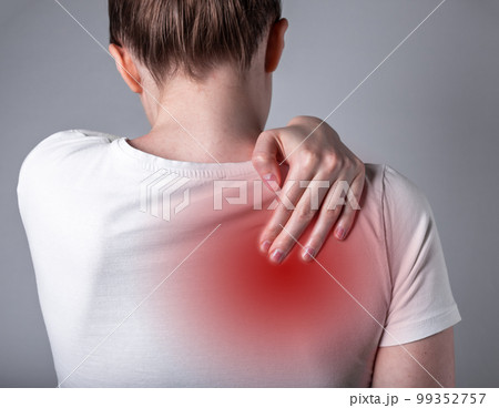 Woman suffering from shoulder blade pain. Trigger point. Hand holding shoulder with red spot closeup. Back injury. Health care, medicine concept 99352757