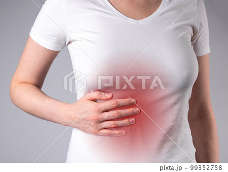 Woman suffering from liver pain. Hand holding abdomen with red point closeup. Stomach ache. Inflammation, liver cirrhosis. Healthy lifestyle concept Woman suffering from liver pain. Hand holding abdomen with red point closeup. Stomach ache. Inflammation, liver cirrhosis. Healthy lifestyle concept 99352758