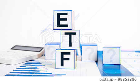 Investing in exchange traded funds. Cubes with ETF abbreviation, calculator and graphs. Financial concept. Making investments in stocks, bonds and commodities Investing in exchange traded funds. Cubes with ETF abbreviation, calculator and graphs. Financial concept. Making investments in stocks, bonds and commodities 99353386