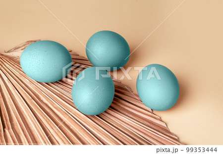 Easter eggs dyed, painted in pastel pale blue colour and dry leaf, minimal composition for spring religious holiday Easter eggs dyed, painted in pastel pale blue colour and dry leaf, minimal composition for spring religious holiday 99353444
