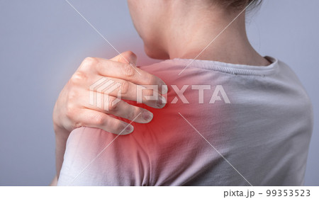 Woman suffering from shoulder pain. Hand holding painful shoulder with red point closeup. Joint injuries. Health care, medicine concept 99353523