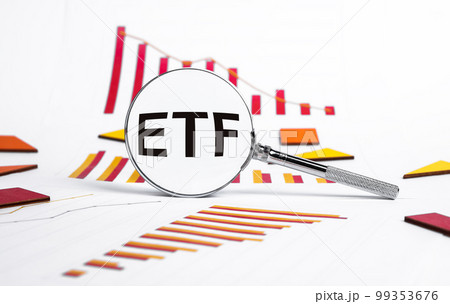 Exchange traded fund. Magnifying glass with ETF text and graphs showing stock market fall. Analysis of economic recession and crisis, risks from shares purchase or sale Exchange traded fund. Magnifying glass with ETF text and graphs showing stock market fall. Analysis of economic recession and crisis, risks from shares purchase or sale 99353676
