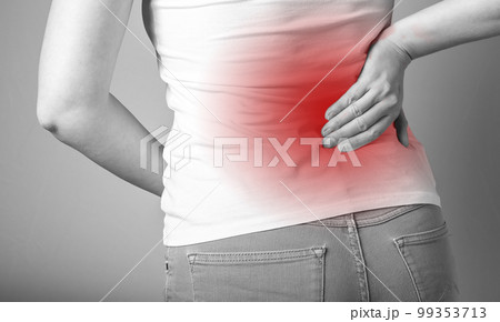 Backache. Woman holding painful lower back with red point closeup. Sport, household injury, chronic diseases. Office syndrome. Health care and medicine concept. Backache. Woman holding painful lower back with red point closeup. Sport, household injury, chronic diseases. Office syndrome. Health care and medicine concept. 99353713