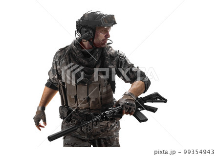 Mercenary soldier walks with an automatic rifle in his hand and looks away. Mercenary soldier walks with an automatic rifle in his hand and looks away. 99354943