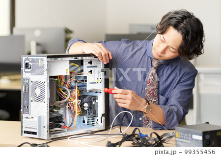 PCを開けて内部をメンテナンスする男性スタッフ　セッティング　キッティング　ビジネスイメージ 99355456