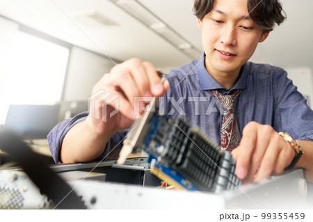 PCを開けてボードをセッティングする男性スタッフ セッティング キッティング ビジネスイメージ PCを開けてボードをセッティングする男性スタッフ セッティング キッティング ビジネスイメージ 99355459