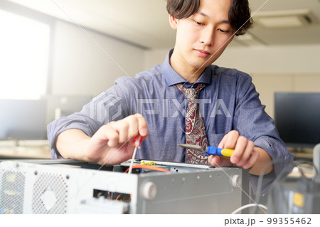 オフィスにてPCをメンテナンスする男性スタッフ セッティング キッティング ビジネスイメージ オフィスにてPCをメンテナンスする男性スタッフ セッティング キッティング ビジネスイメージ 99355462