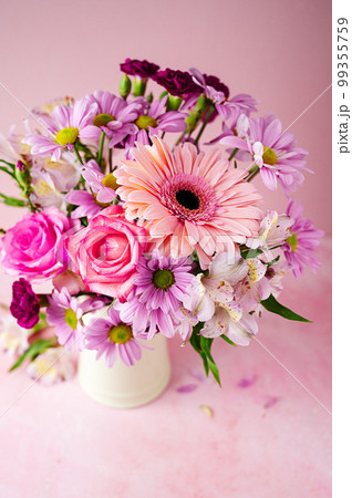 Beautiful fresh spring flowers. Pink bouquet of flowers in vase, on pink background. 99355759