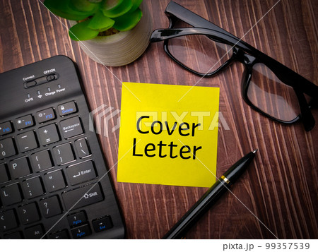 Keyboard,pen and glasses with the word Cover Letter on wooden table background. 99357539