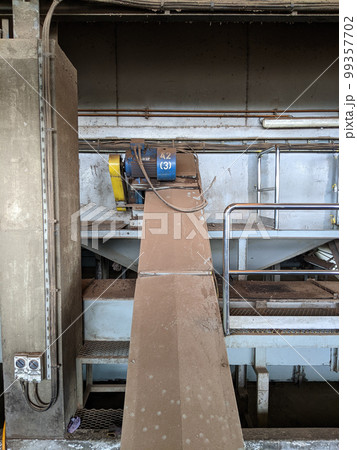 Malaysia, 25 May 2022: A blue palm kernel intake conveyor motor located in a palm kernel processing plant. Malaysia, 25 May 2022: A blue palm kernel intake conveyor motor located in a palm kernel processing plant. 99357702