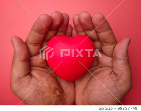 Hand holding red love heart on a red background. Healthcare and valentine concept. Hand holding red love heart on a red background. Healthcare and valentine concept. 99357749
