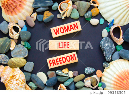 Woman life freedom symbol. Concept words Woman Life Freedom on wooden blocks on a beautiful black table black background. Sea stone, sea shell. Social issue woman life freedom concept. Copy space. Woman life freedom symbol. Concept words Woman Life Freedom on wooden blocks on a beautiful black table black background. Sea stone, sea shell. Social issue woman life freedom concept. Copy space. 99358505