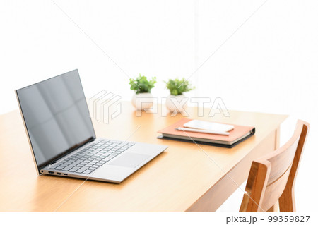 屋内のテーブルにノートパソコンとシステム手帳とスマホがある様子 99359827