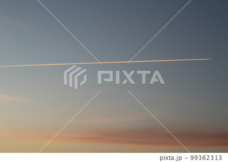 軌跡と飛行機雲　朝焼けの空 99362313