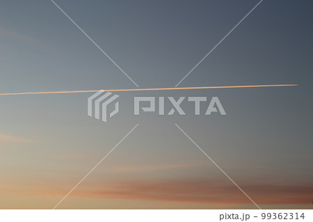 軌跡と飛行機雲　朝焼けの空 99362314