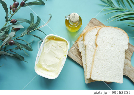 fresh olive butter in a container with bread on table  99362853