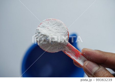 Washing powder in plastic spoon on black background top view. Washing powder in plastic spoon on black background top view. 99363239